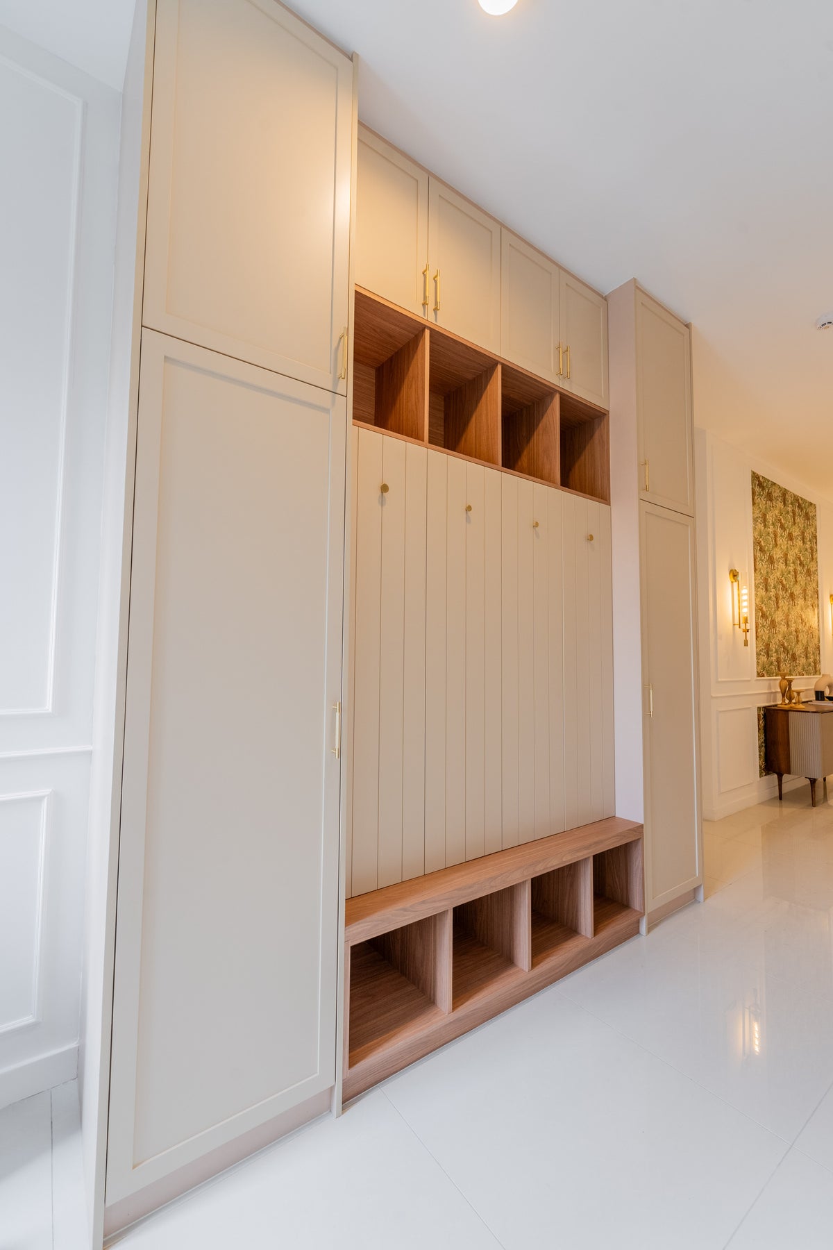 Entrance hall with full-height cream cabinets, open timber shoe cubbies and a built-in bench, in a home Sundays in Bed designed at Setia Sky Seputeh
