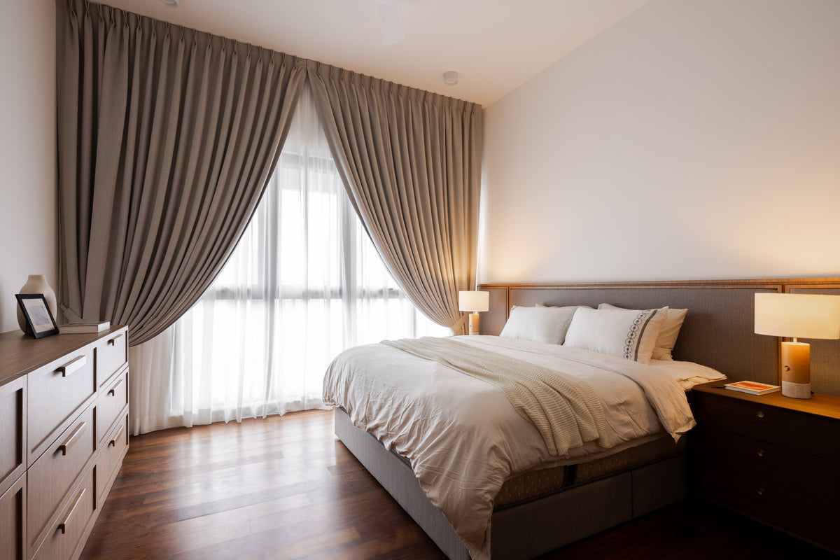 A bedroom with drapes hung from the ceiling over sheers and a chest of drawers, in a home Sundays in Bed designed at Setia Sky Seputeh, Seputeh