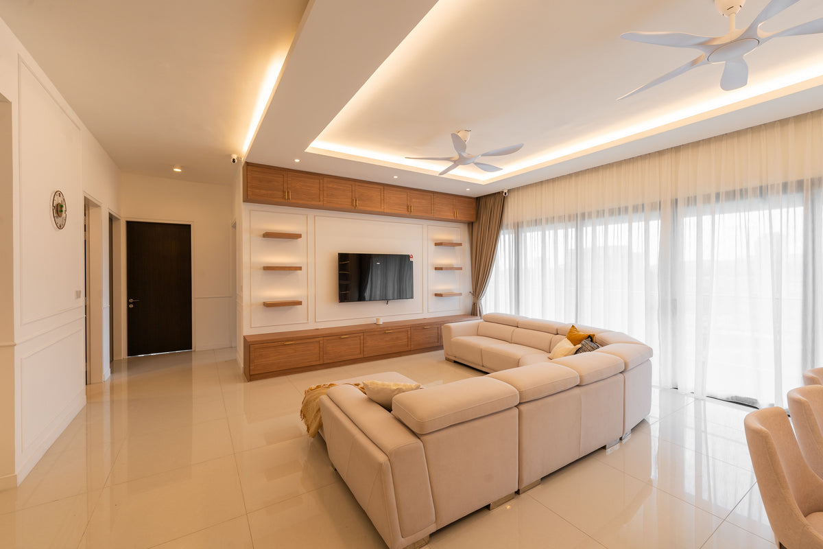 A living room with a timber television wall, a cream sectional and full-height sheers, in a home Sundays in Bed designed at Setia Sky Seputeh, Seputeh