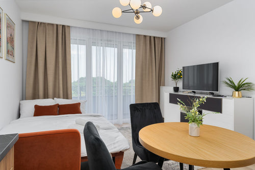 Compact studio condo combining bed, dining table and living space in one room