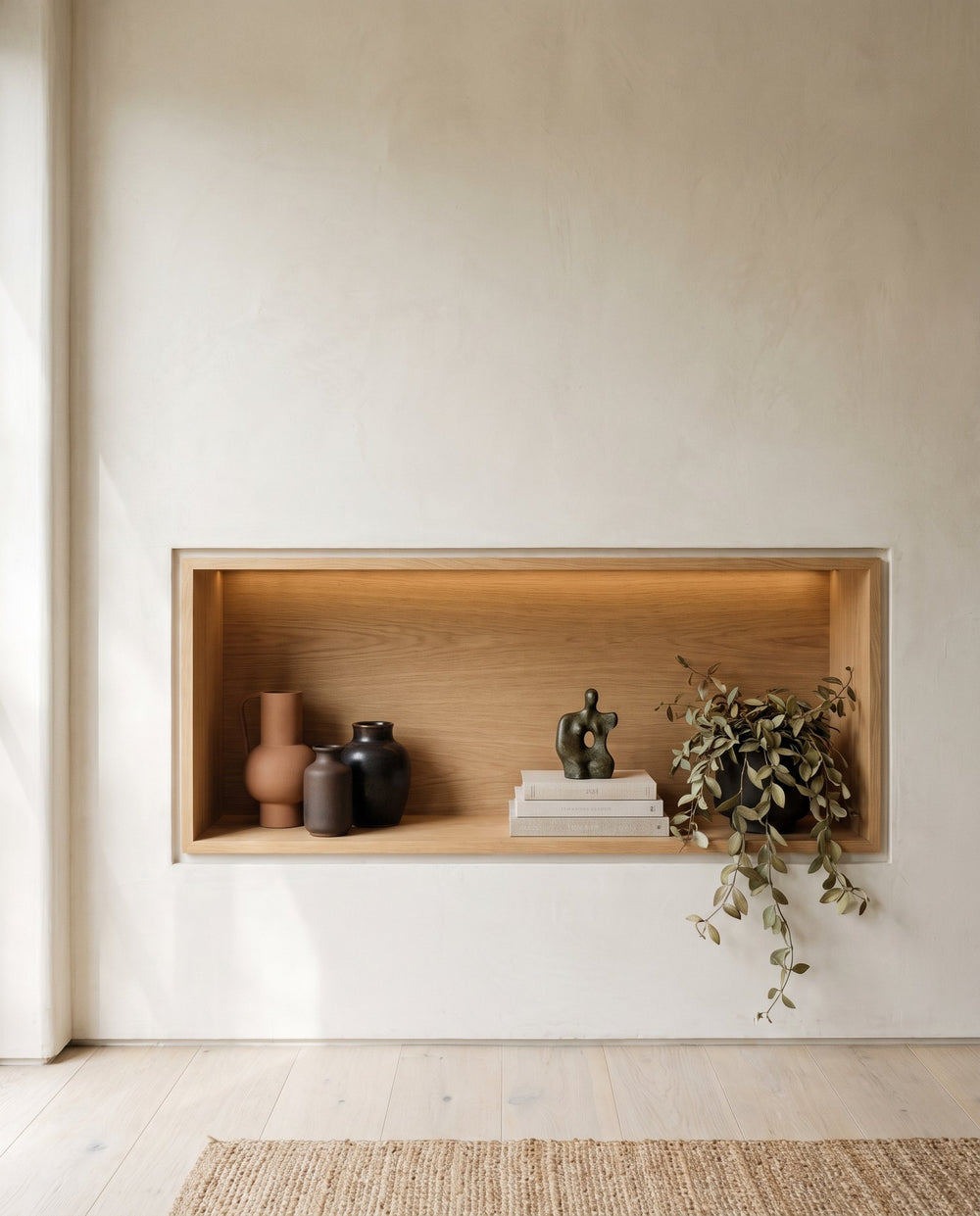 Backlit oak display niche showing both the joinery detail and the styling on its shelves