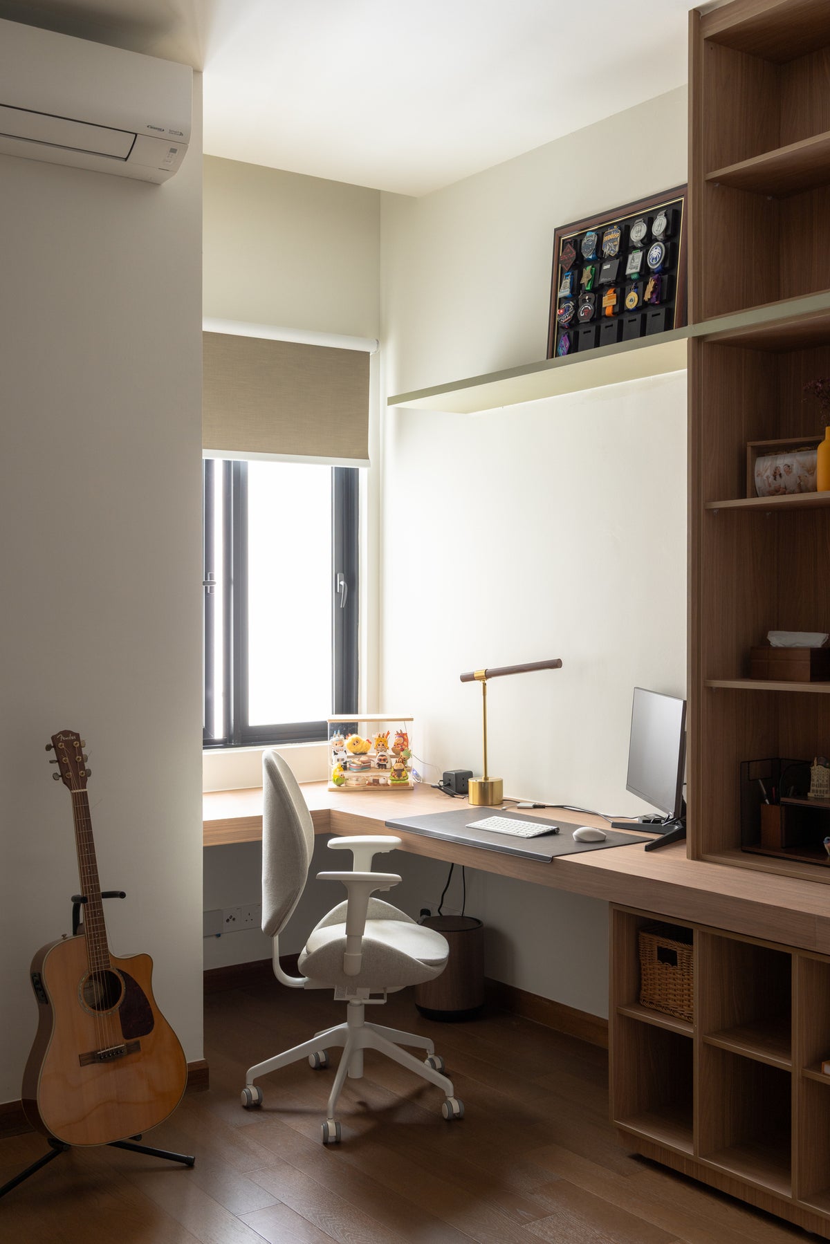 A built-in desk with a window, a roller blind and timber shelving, in a home Sundays in Bed designed at Bangsar Hill Park, Bangsar