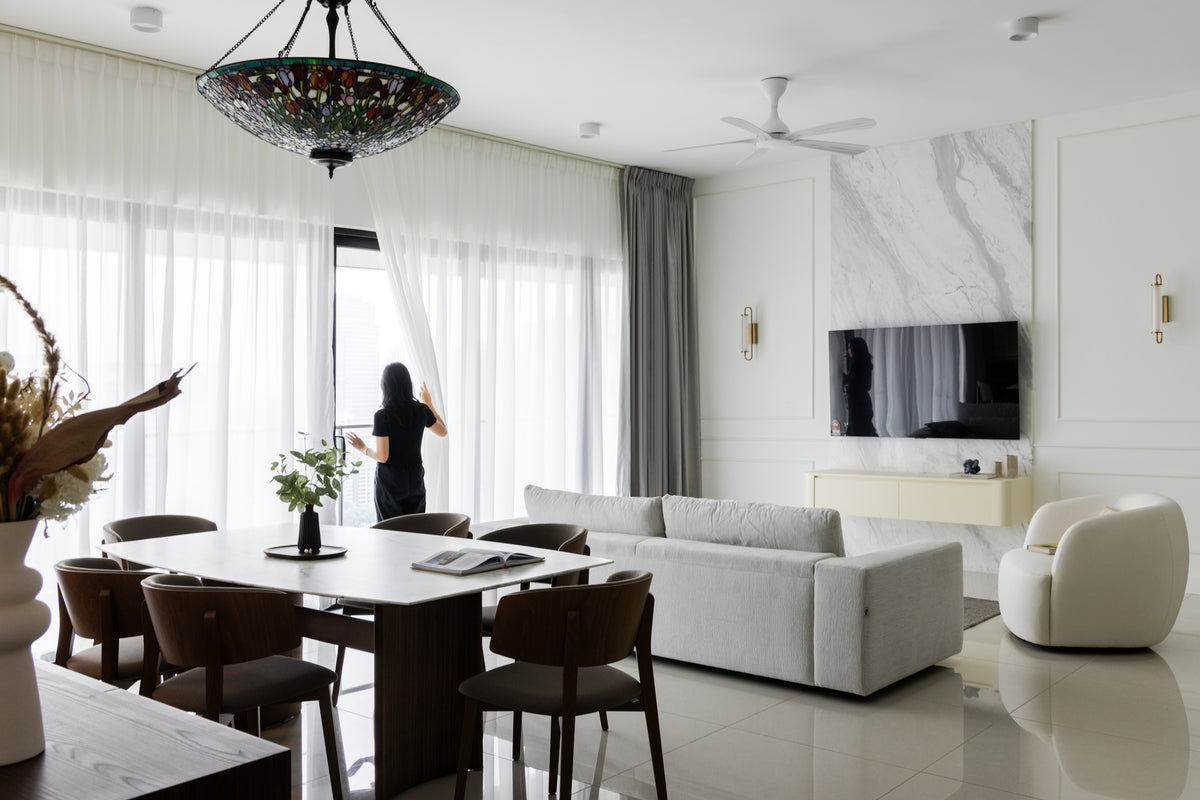 An open-plan living and dining area in a Klang Valley house, seen across the full width of the floor plate
